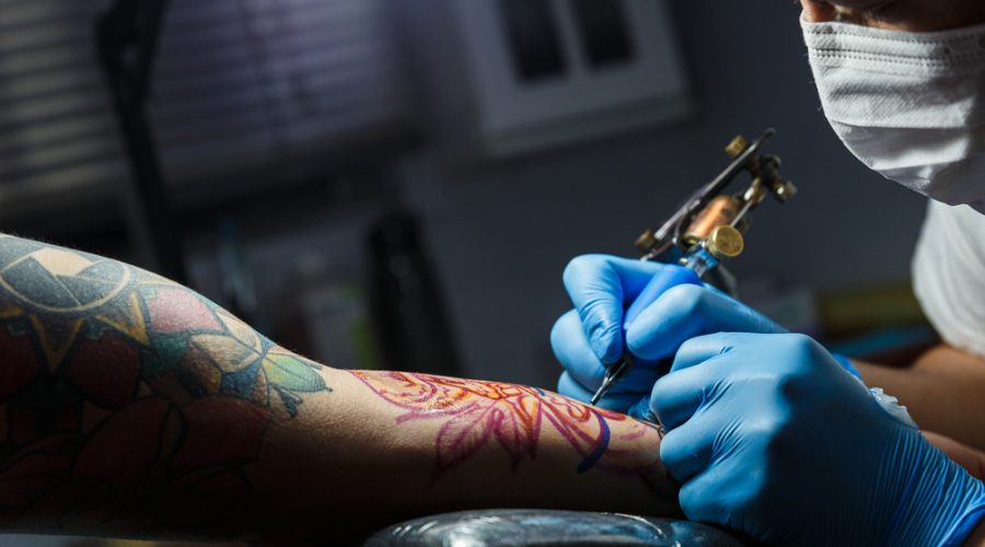 Tattooist,With,His,Machine,Tattooing,On,The,Arm,With,The